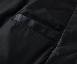 Detail of premium black PU leather and fabric stitching on men's mid-length casual jacket