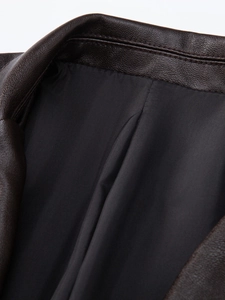 Detail view of the dark brown PU leather jacket collar with pebble grain texture and lining