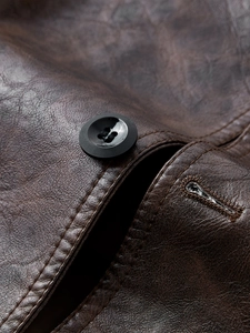 Macro shot of durable dark brown leather texture with precise stitching and black button detail