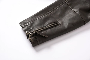 Close-up of vintage PU leather jacket cuff featuring metallic zipper and fine stitching