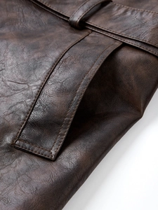 Macro view of dark brown leather texture with precise stitching on belt and pocket flap