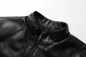Detail of black PU leather jacket featuring a stand collar and metallic zipper texture