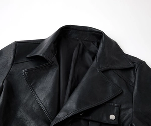 Detailed close-up of premium black PU leather lapel and silver metal button on trench coat
