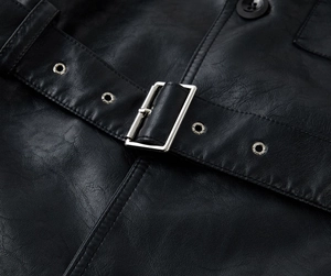 Detail of black PU leather trench coat featuring waist belt with silver buckle and hardware
