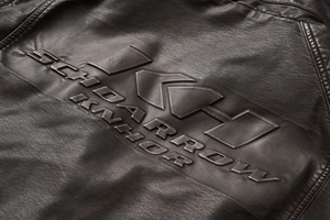 Detailed view of the 3D embossed logo and vintage texture on the men's PU leather jacket