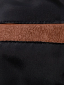 Detail of black nylon fabric stitched with brown lychee pattern leather on casual jacket