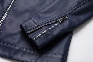 Detail of silver metal zipper and fine stitching on navy blue PU leather jacket cuff