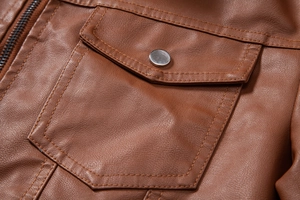 Close-up of caramel brown PU leather jacket showing pocket flap and silver metal snap button