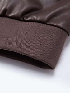 Dettaglio della manica della giacca in similpelle marrone scuro con polsino in maglia a coste