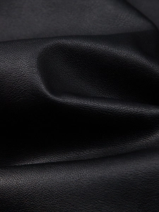 Detailed macro view showing the textured black PU leather grain and soft material of the jacket