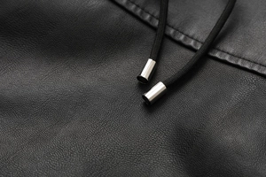 Detail of black lychee grain PU leather jacket with braided drawstring and silver metal tips