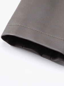 Close-up detail of dark grey PU leather jacket showing litchi grain texture and stitching