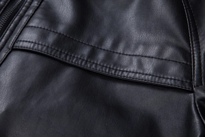 Detailed macro view of black PU leather jacket showing grain texture and double stitching