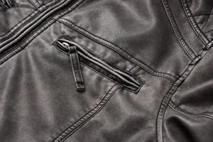 Detail of vintage PU leather jacket featuring zippered pocket and diamond quilt stitching