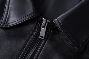 Close-up of black PU leather jacket lapel featuring metallic zipper and premium stitching
