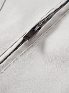 Close-up of white PU leather jacket with premium charcoal gray metal zipper and stitching