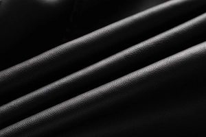 Close-up of black washed PU leather jacket showing detailed lychee grain texture