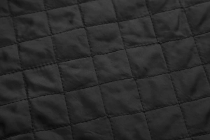 Close-up of black diamond-quilted fabric detail on motorcycle jacket inner lining