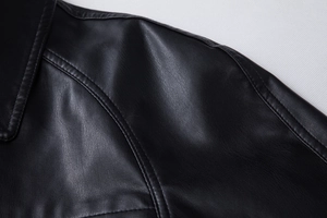 Close-up of lapel and shoulder seams showing stitching on black PU leather jacket