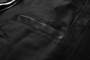 Detail of metal zipper and leather trim on men's detachable hooded motorcycle jacket