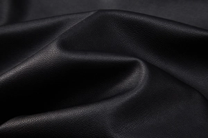 Close-up of black PU leather texture with lychee grain showing soft material quality