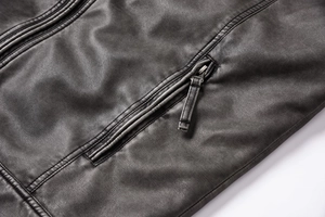 Close-up of black PU leather jacket featuring textured lychee grain and metal zipper pocket