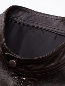 Close-up of brown PU leather jacket featuring a stand collar with metallic snap button