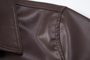 Macro shot showing high-quality lychee texture and stitching on dark brown PU leather jacket