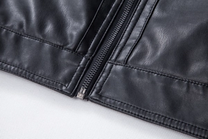 Detail shot of black faux leather jacket texture with high-quality metal zipper and stitching