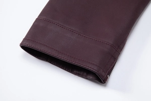 Detailed macro shot of deep burgundy PU leather jacket cuff with premium metal zipper