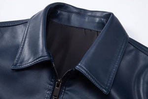 Detailed view of navy blue PU leather jacket lapel with gunmetal zipper texture
