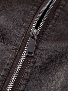 Detail of metal zipper on dark brown faux leather jacket with lychee texture pattern