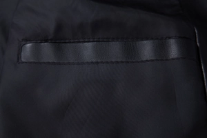 Detailed close-up of a men's faux leather jacket pocket with precise stitching and trim