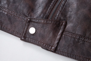 Detail shot of brown PU leather jacket featuring adjustable waist buckle and metal zipper
