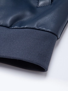 Dettaglio della trama in pelle PU blu scuro e dei polsini a coste sulla giacca da uomo