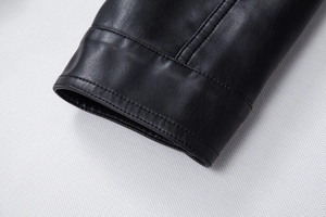 Detail of black faux leather jacket cuff featuring professional double stitching and texture