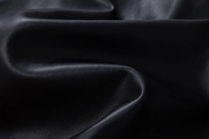 Detailed macro view of black PU leather texture with matte finish and lychee grain pattern