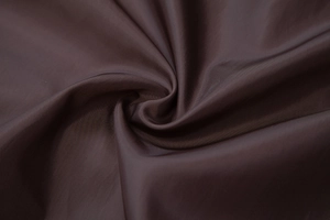 Close-up of deep brown racing jacket inner lining with smooth silk-like texture