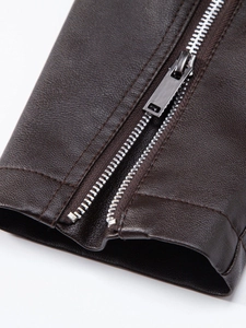 Detail of metal zipper and brushed slider on dark brown textured faux leather jacket