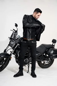 Close-up of black PU leather jacket with vintage belt and motorcycle styling detail