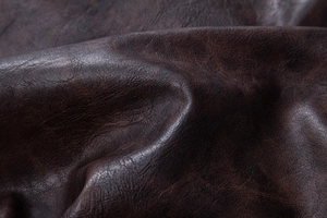 Close-up of deep brown PU leather texture on the men's vintage motorcycle jacket
