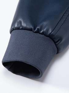 Dettaglio del polsino a coste sulla giacca da motociclista in ecopelle blu navy