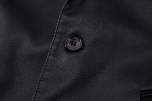 Détail macro de la texture du cuir PU noir avec bouton et coutures de haute précision