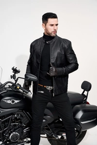 Detail of black faux leather motorcycle jacket featuring a sleek stand collar and metallic zipper