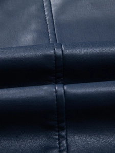 Dettaglio della trama in ecopelle blu scuro con cuciture precise sulla giacca biker