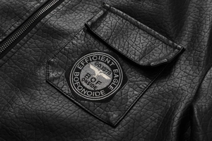 Macro detail of men's PU leather jacket featuring eagle embroidery and metal zipper