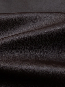 Detailed macro view of dark brown PU leather jacket with premium lychee grain texture