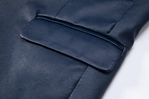 Détail du grain de cuir PU bleu marine et de la poche cousue sur la veste élégante