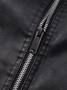 Detailed macro view of silver metallic zipper and grainy leather texture on men's jacket
