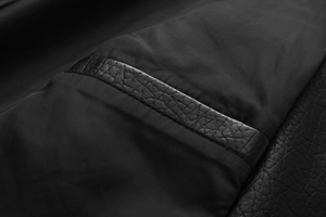 Macro shot of faux leather texture and precise stitching on black biker jacket sleeves